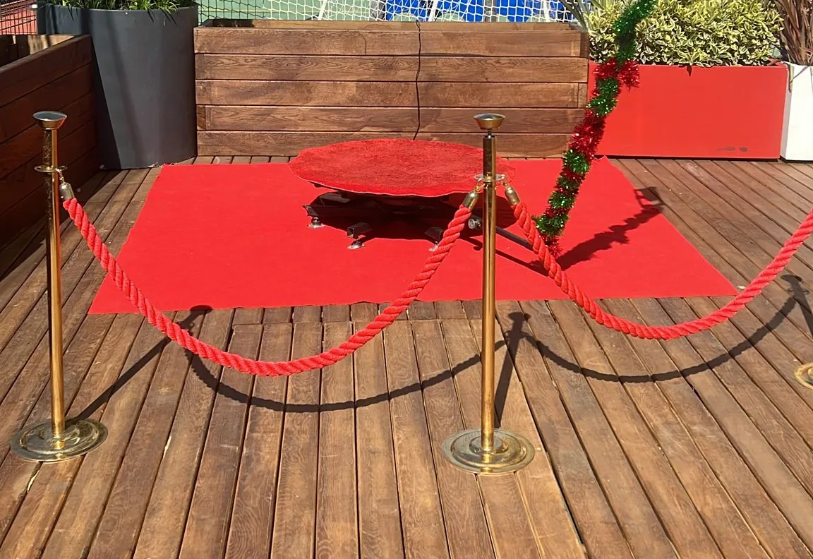 Açık hava terasında kırmızı halı üzerinde 360 video booth kurulumu