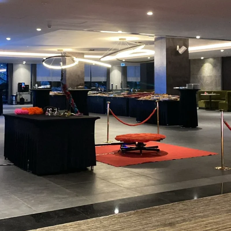 Otel lobisinde kırmızı halı ve dikmelerle kurulmuş 360 video booth platformu