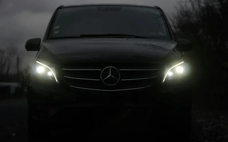 Farları yanan siyah Mercedes minivan